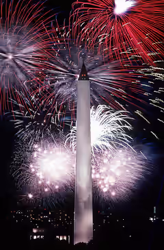 Fourth of July fireworks surrounding the Washington Monument at night