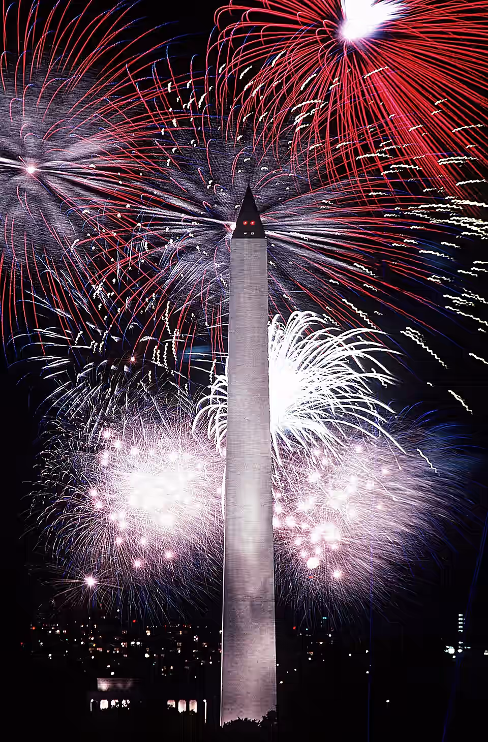 Fourth of July fireworks surrounding the Washington Monument at night