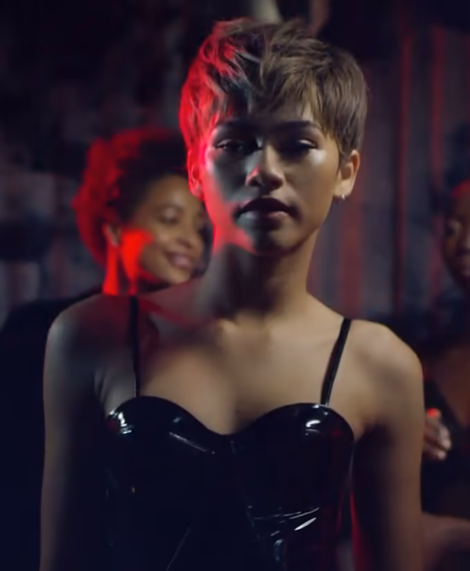 Zendaya facing the camera in a red-lit frame from a Daya by Zendaya fashion film